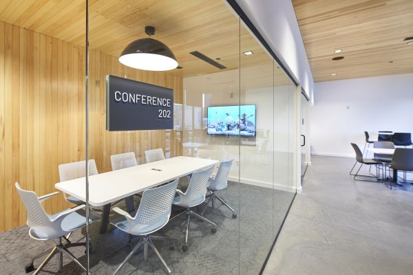 Conference room at VERVE St. Louis with long white conference table, chairs surrounding it, and a flatscreen tv on the wall