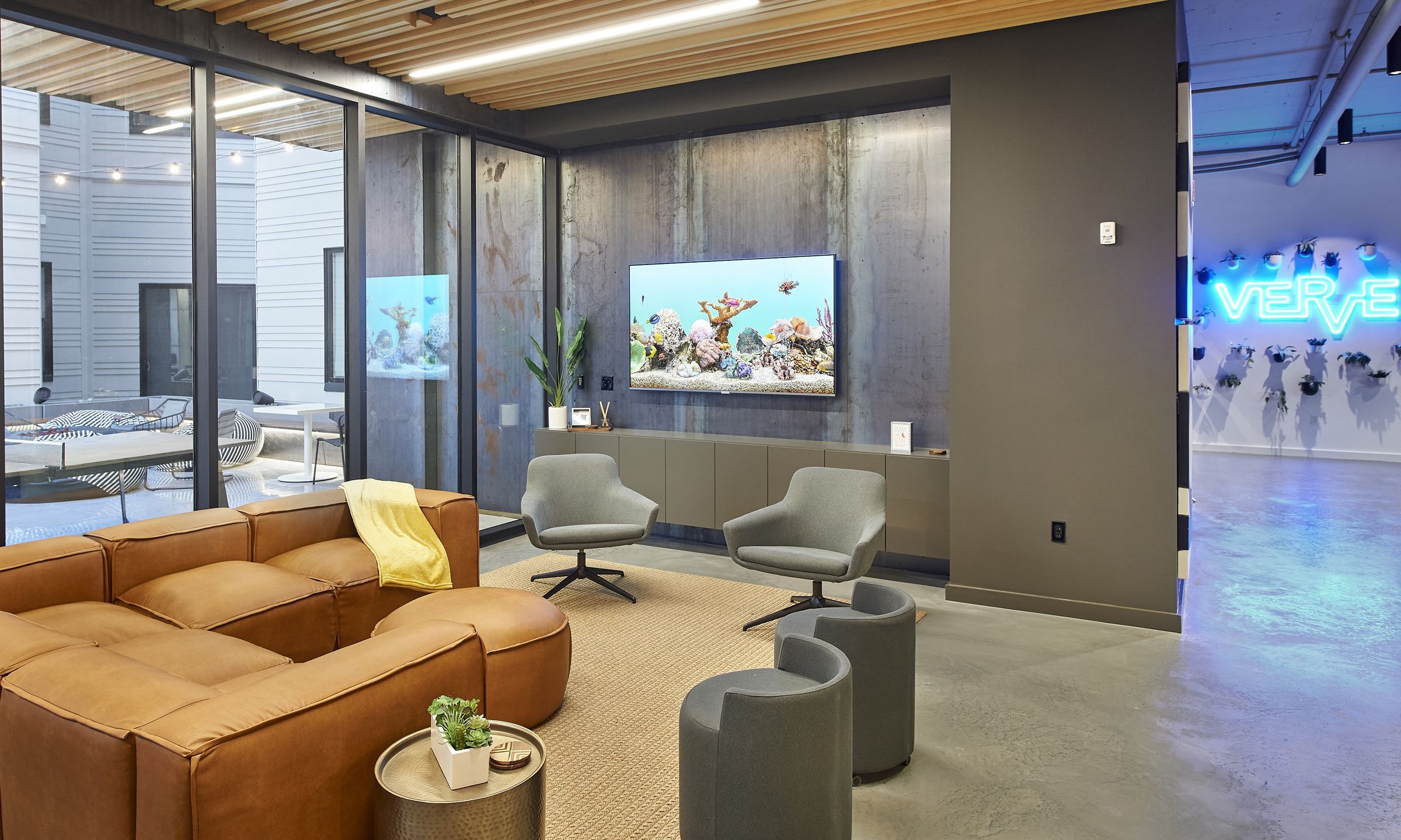 Club room at VERVE St. Louis with leather couch, modern decoration, and a tv on the wall