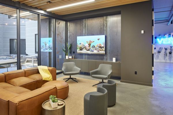 Club room at VERVE St. Louis with leather couch, modern decoration, and a tv on the wall