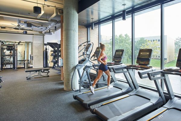 Girl running on treadmill in community gym amenity at VERVE St. Louis 